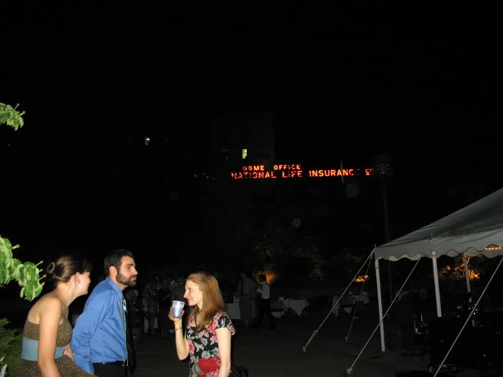 Two people in conversation at night, lit only by warm indoor light