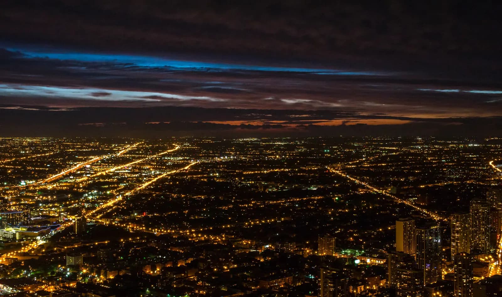 Große Stadt in der Abenddämmerung mit vielen Lichtern bis zum Horizont
